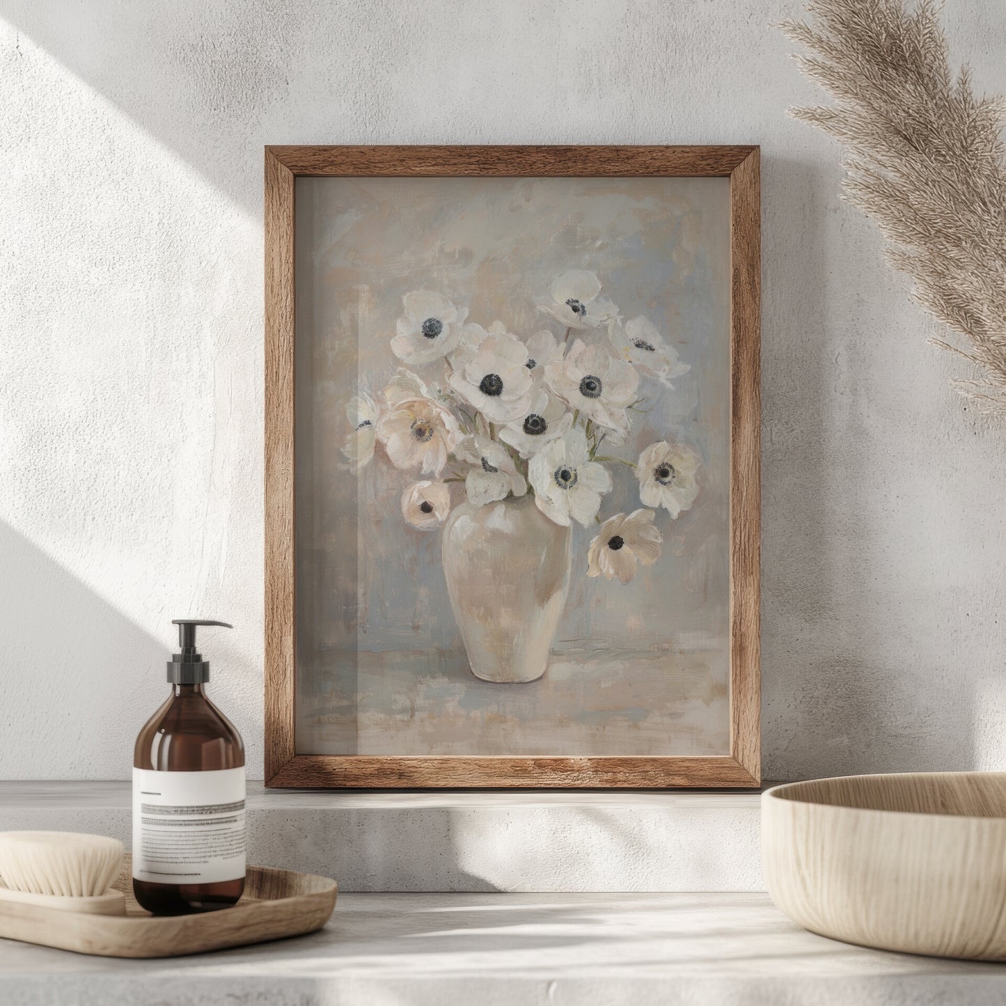Framed artwork of a floral still life on a neutral wall with decorative items below.