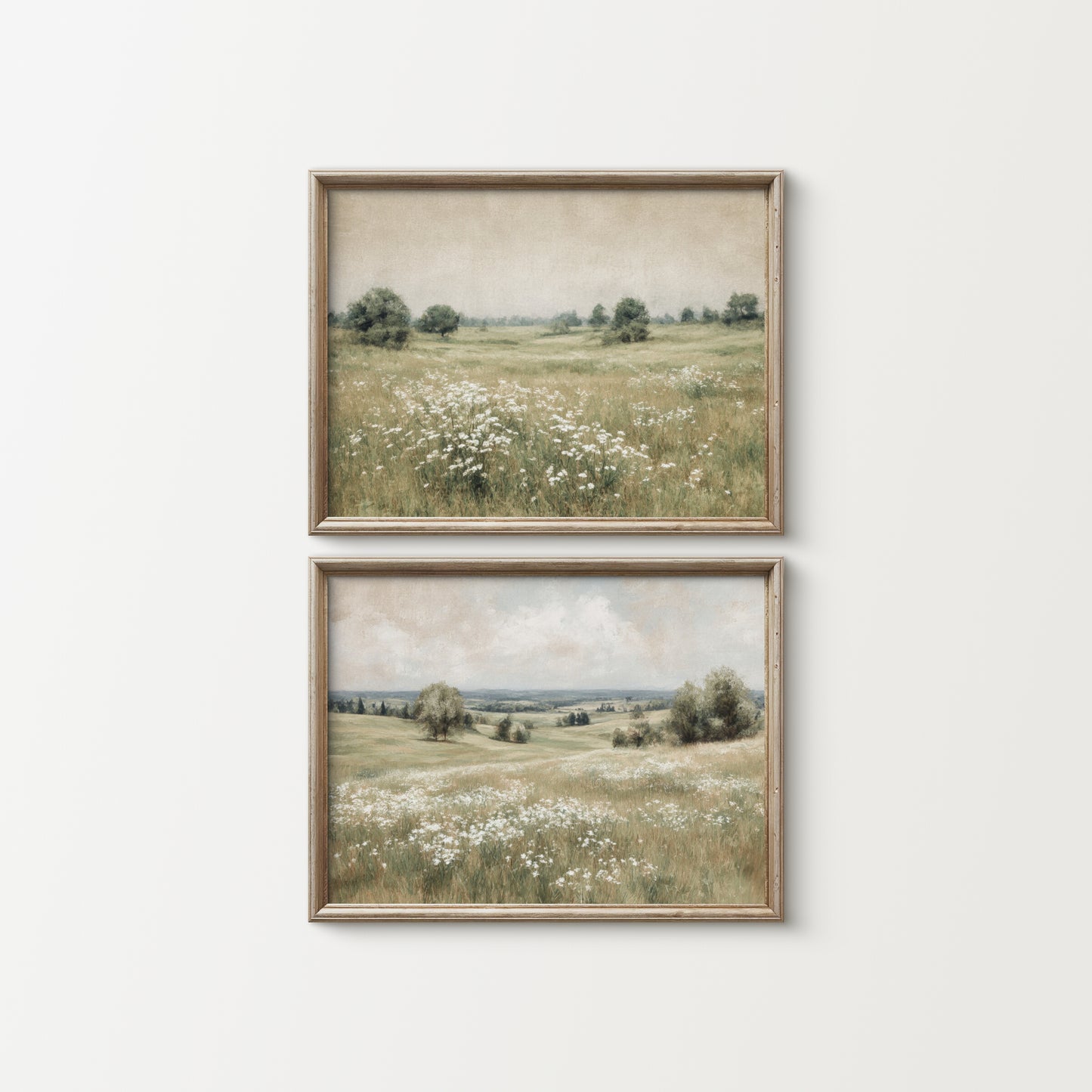 Two framed landscape prints of a field with flowers on a white wall.