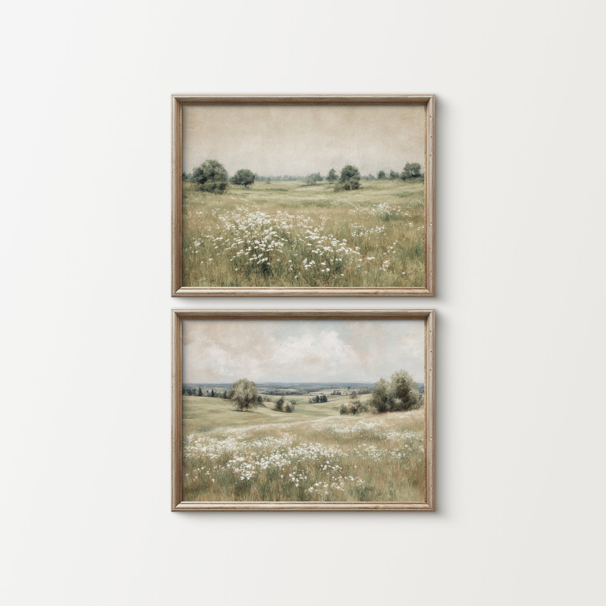 Two framed landscape prints of a field with flowers on a white wall.