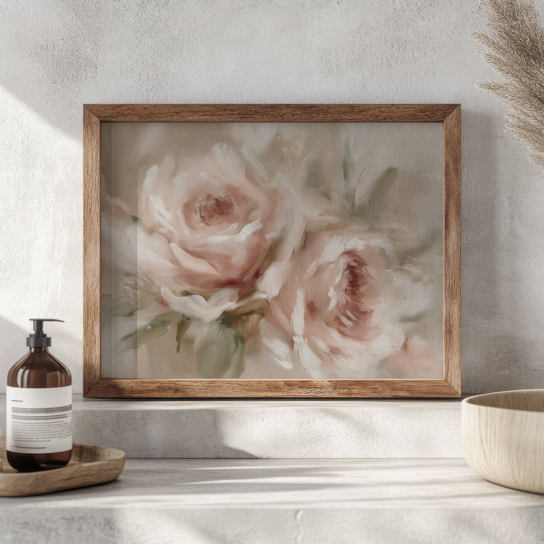 Framed floral painting on a wall with a bottle and bowl in the foreground.