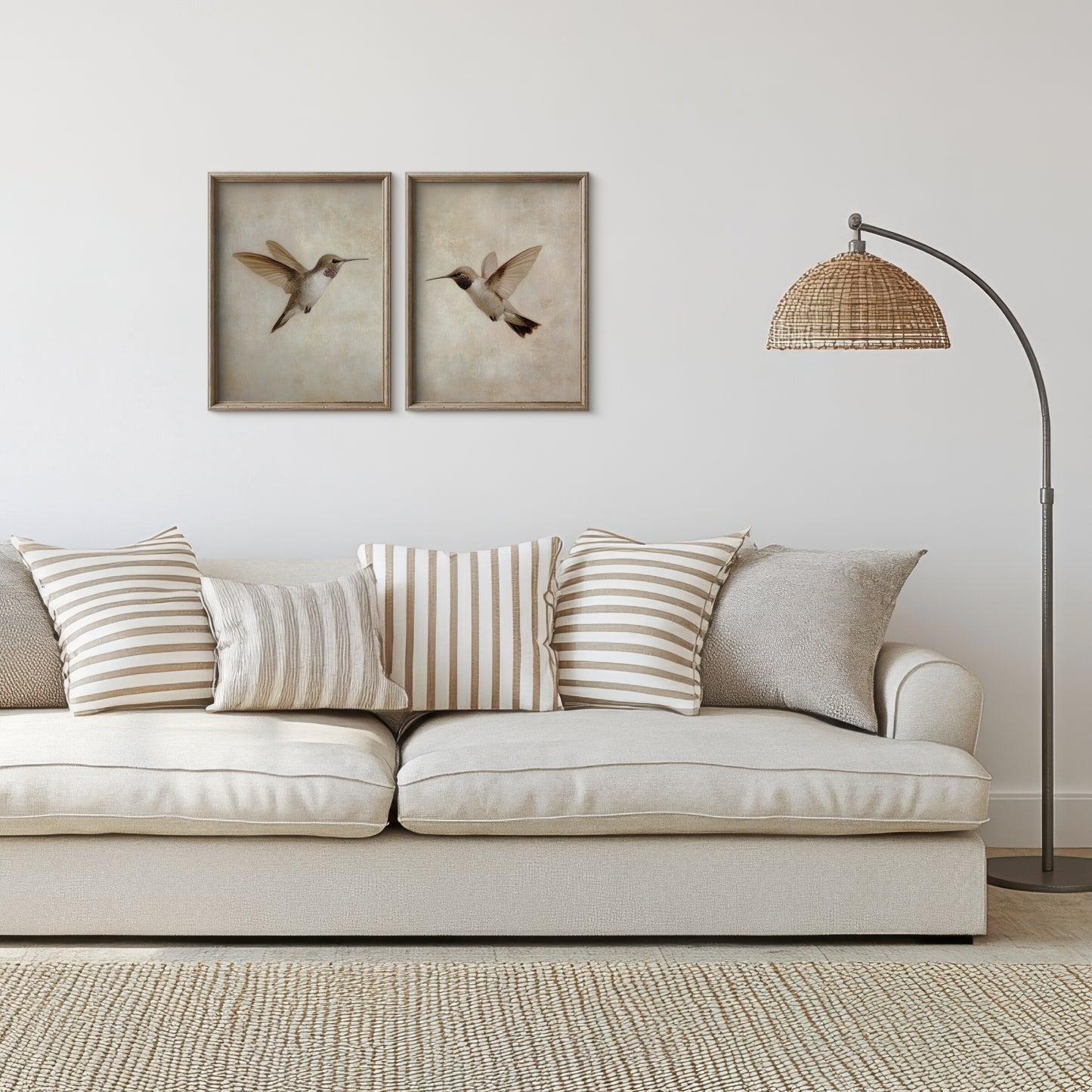 Beige sofa with striped cushions in a living room setting with framed artwork and a floor lamp.