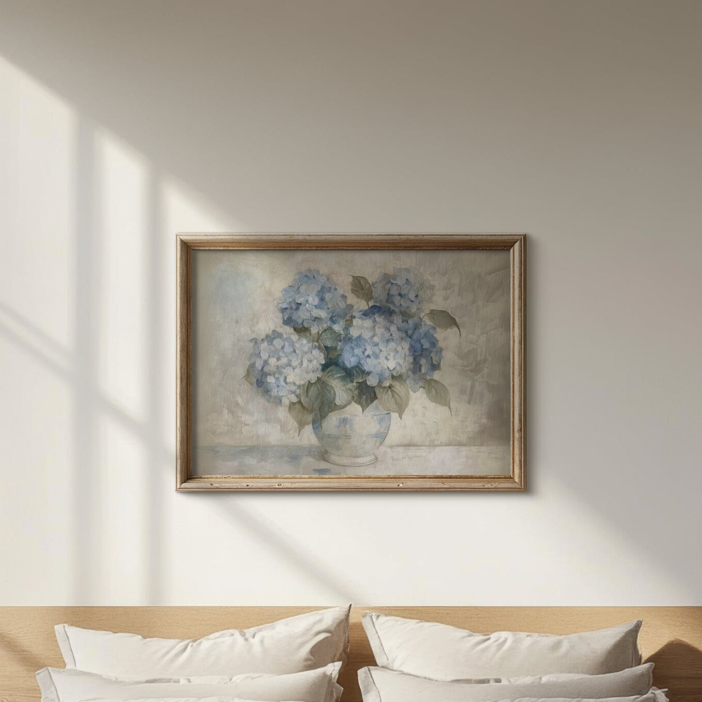 Framed artwork of blue flowers on a wall above a bed.