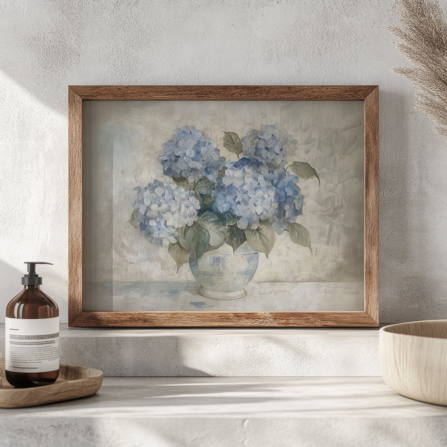 Framed artwork of blue hydrangeas on a shelf with a bottle and bowl.