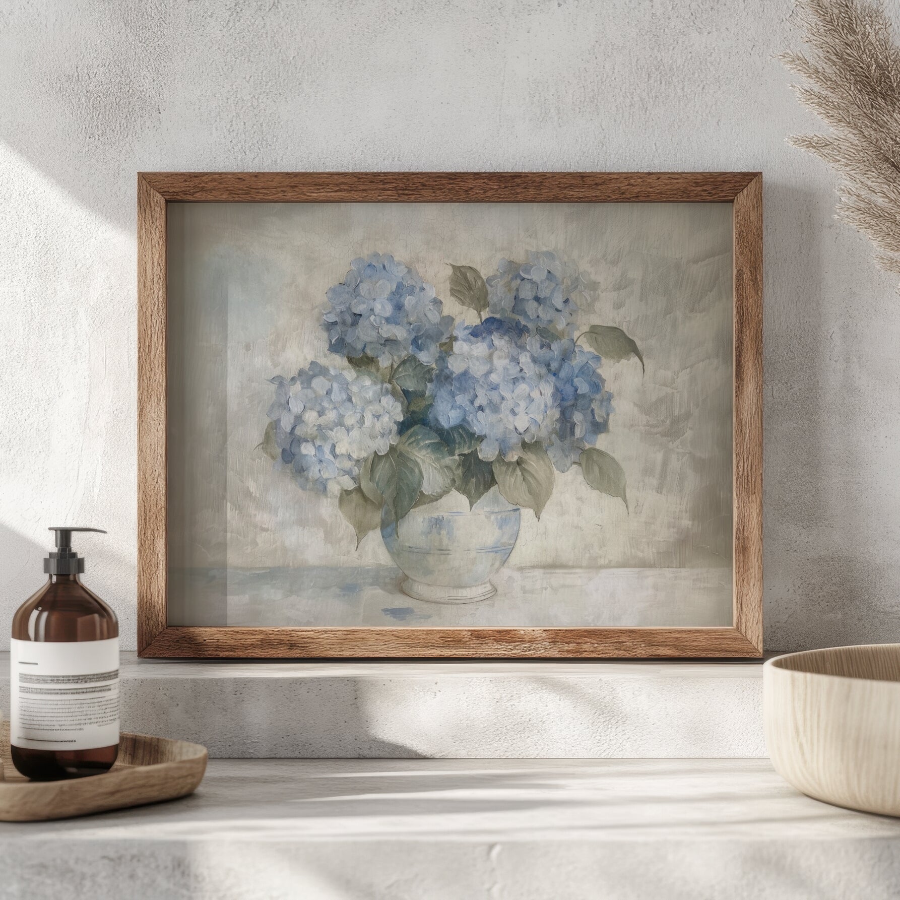 Framed artwork of blue hydrangeas on a shelf with a bottle and bowl.