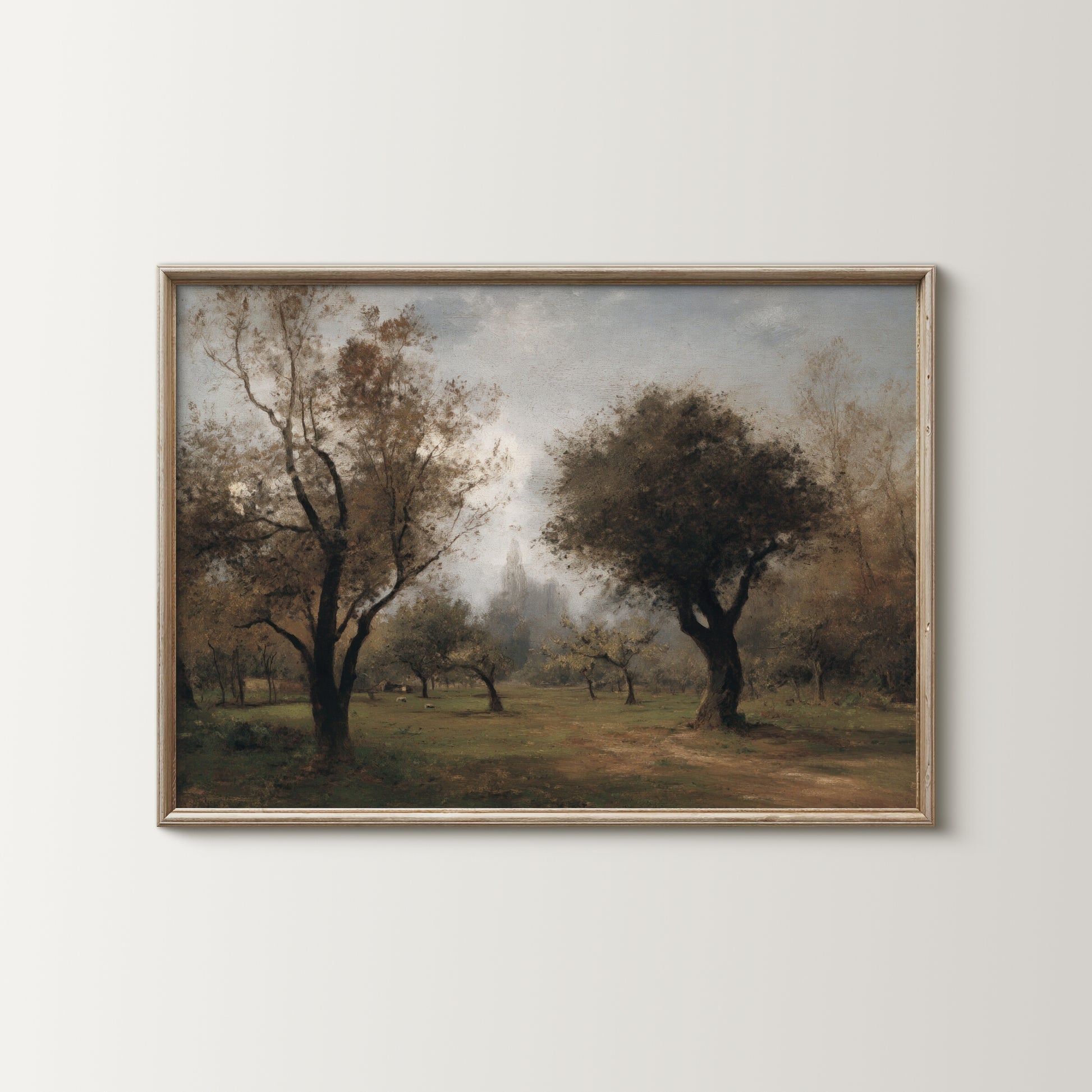 Framed painting of a landscape with trees and a path on a white wall