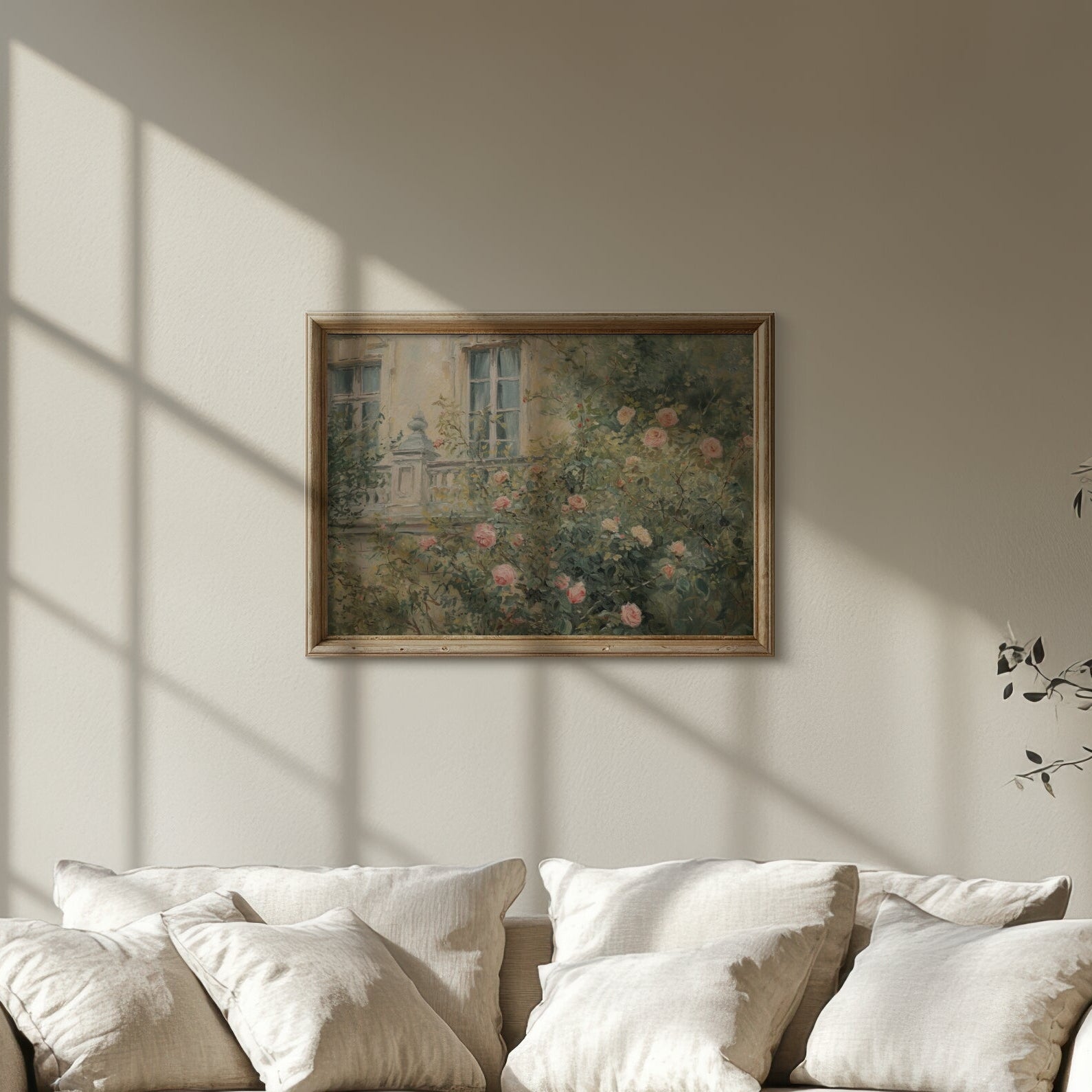White sofa in a room with sunlight streaming through a window, casting shadows on the wall.