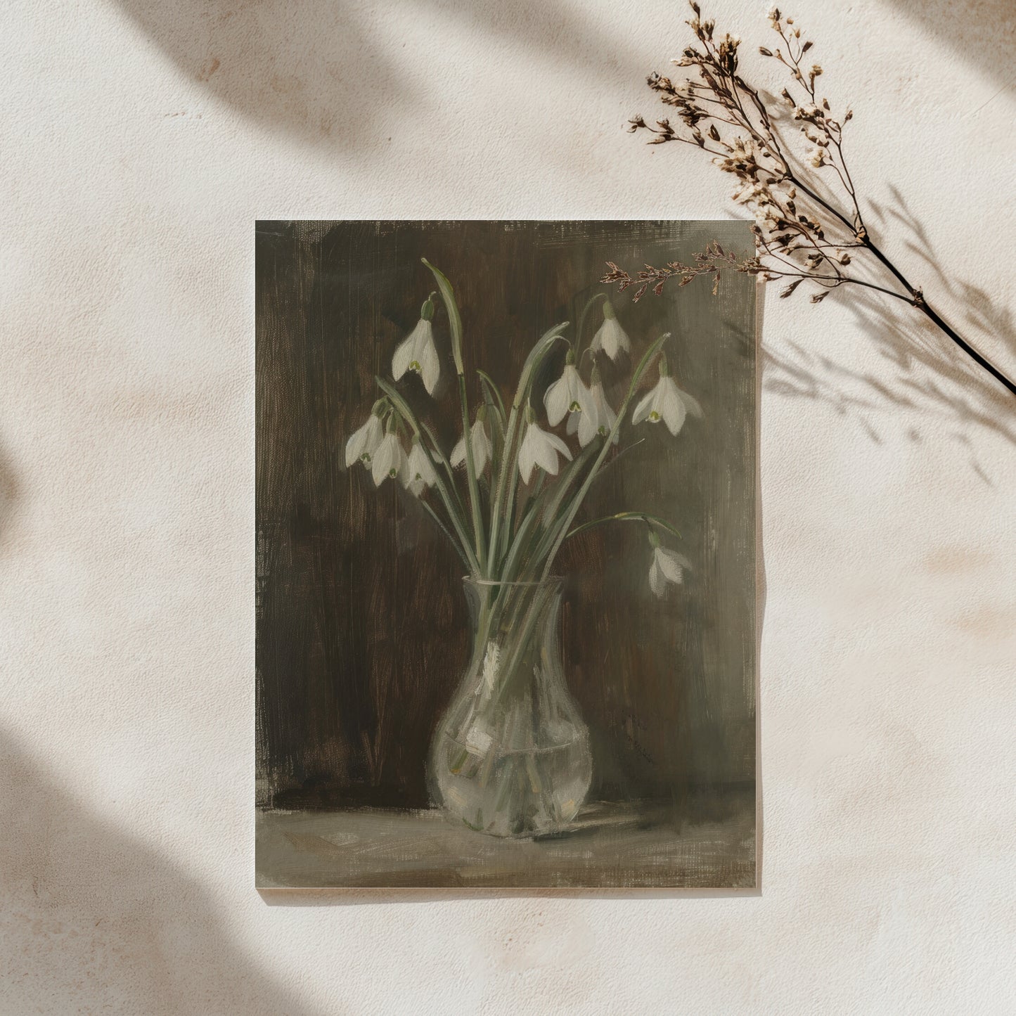 Framed artwork of snowdrops in a vase on a textured wall.