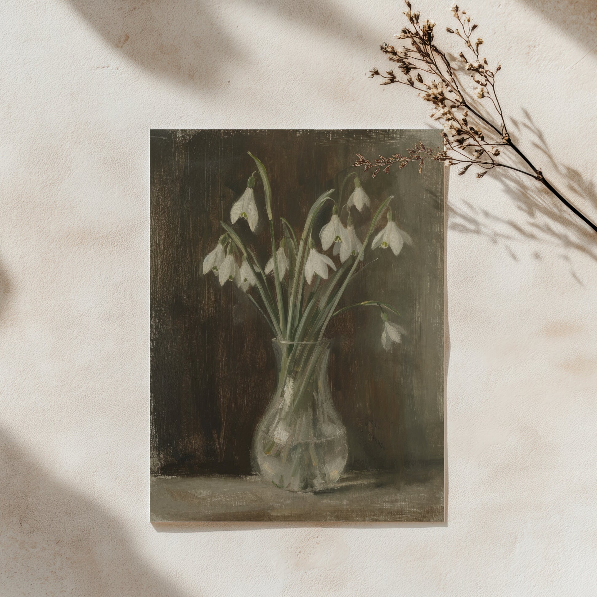 Framed artwork of snowdrops in a vase on a textured wall.