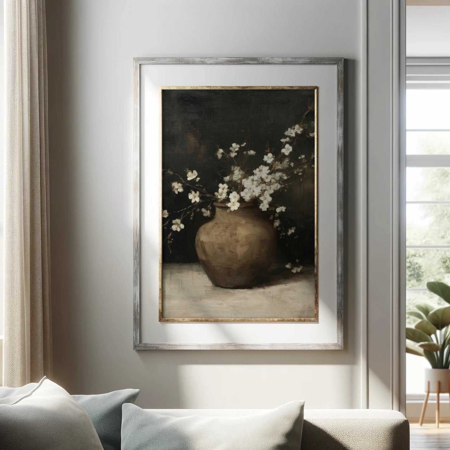 Framed artwork of a vase with white flowers on a wall in a living room.