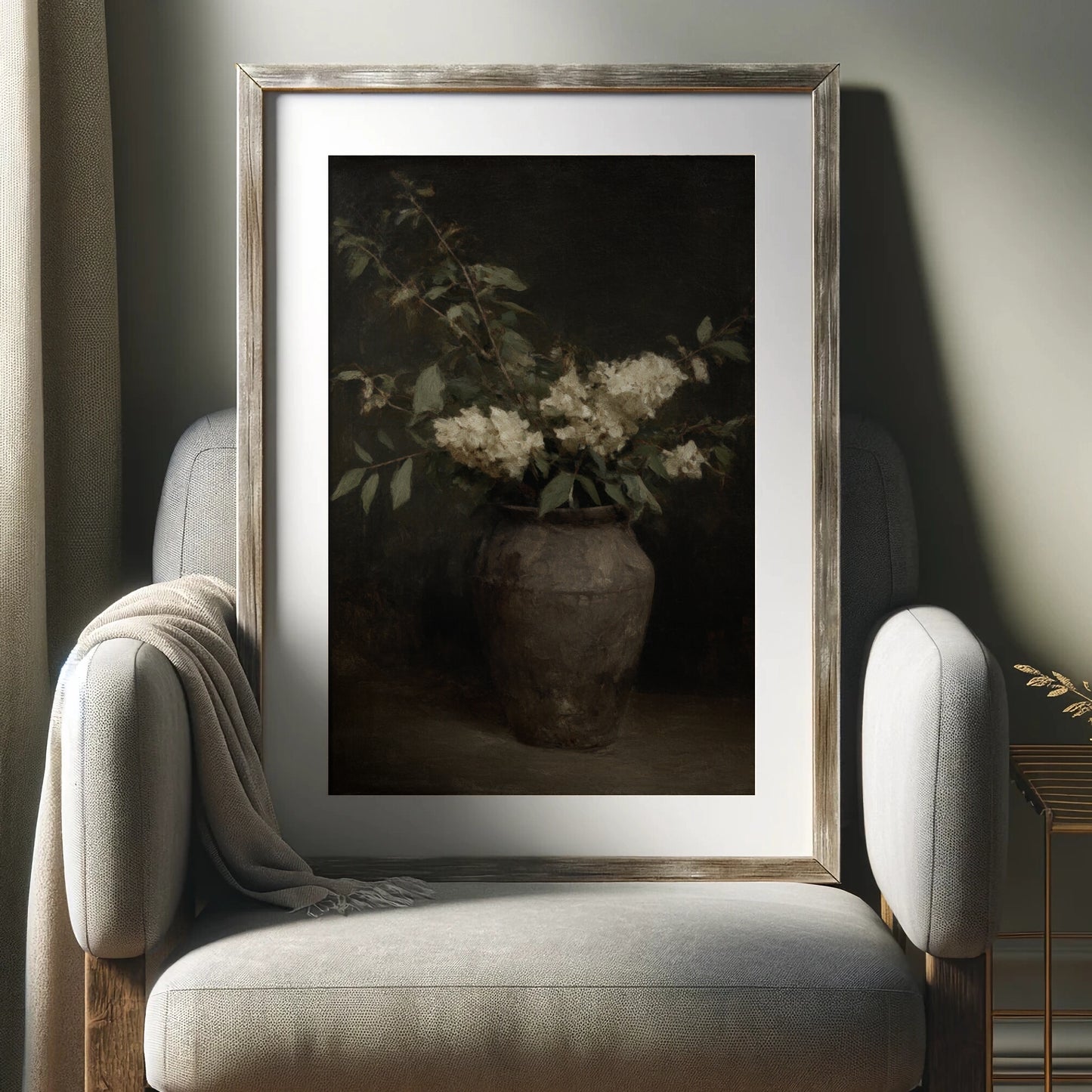 Framed artwork of a vase with flowers on a gray armchair