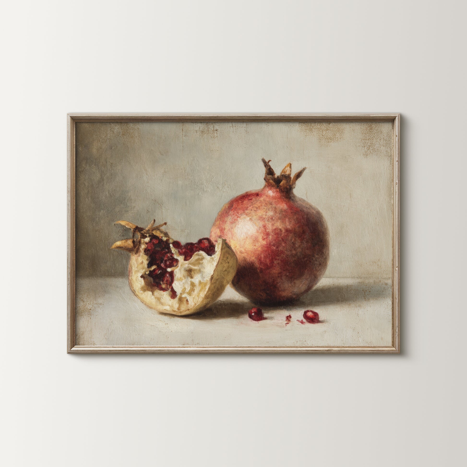 Framed artwork of a pomegranate with one half open on a neutral background