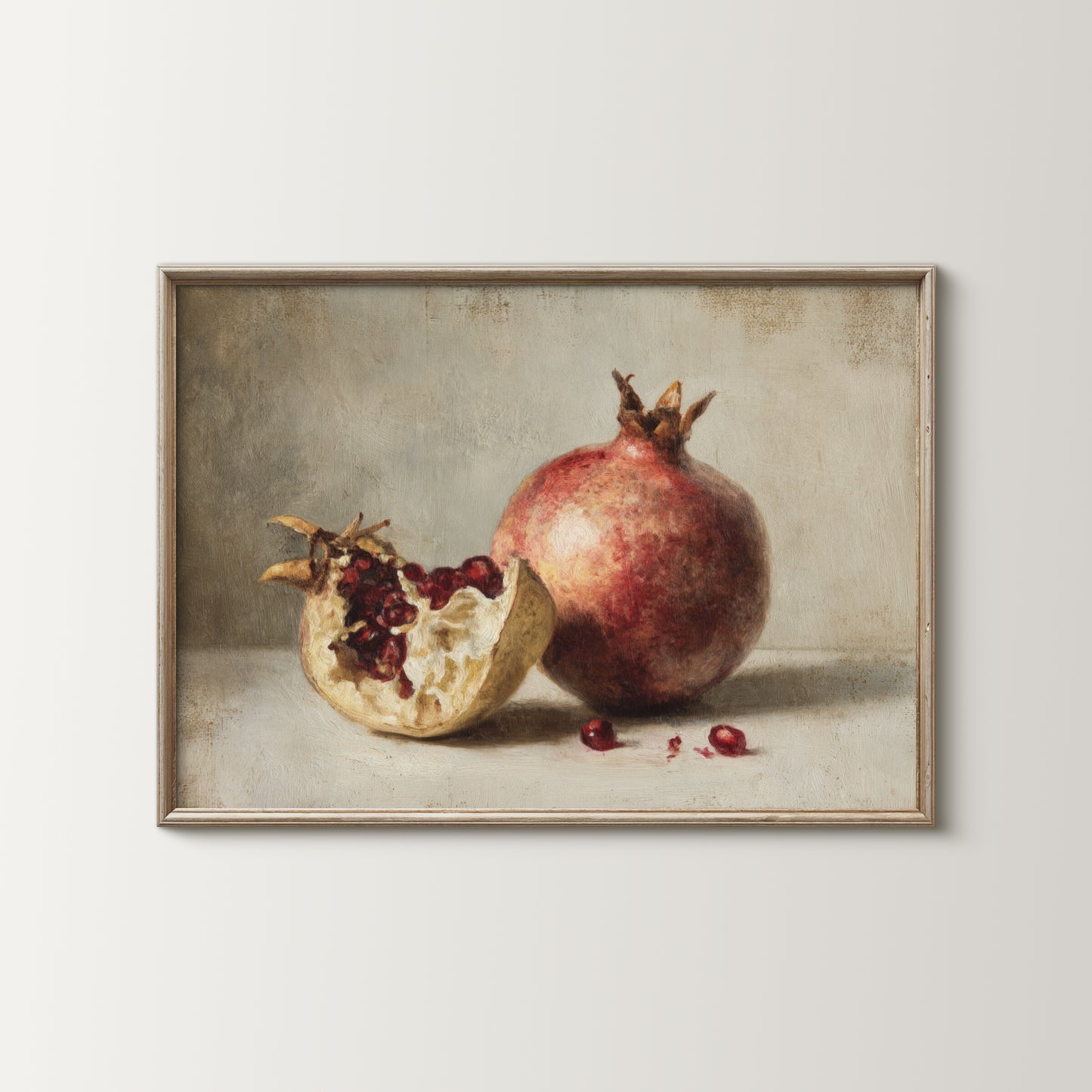 Framed artwork of a pomegranate with one half open on a neutral background