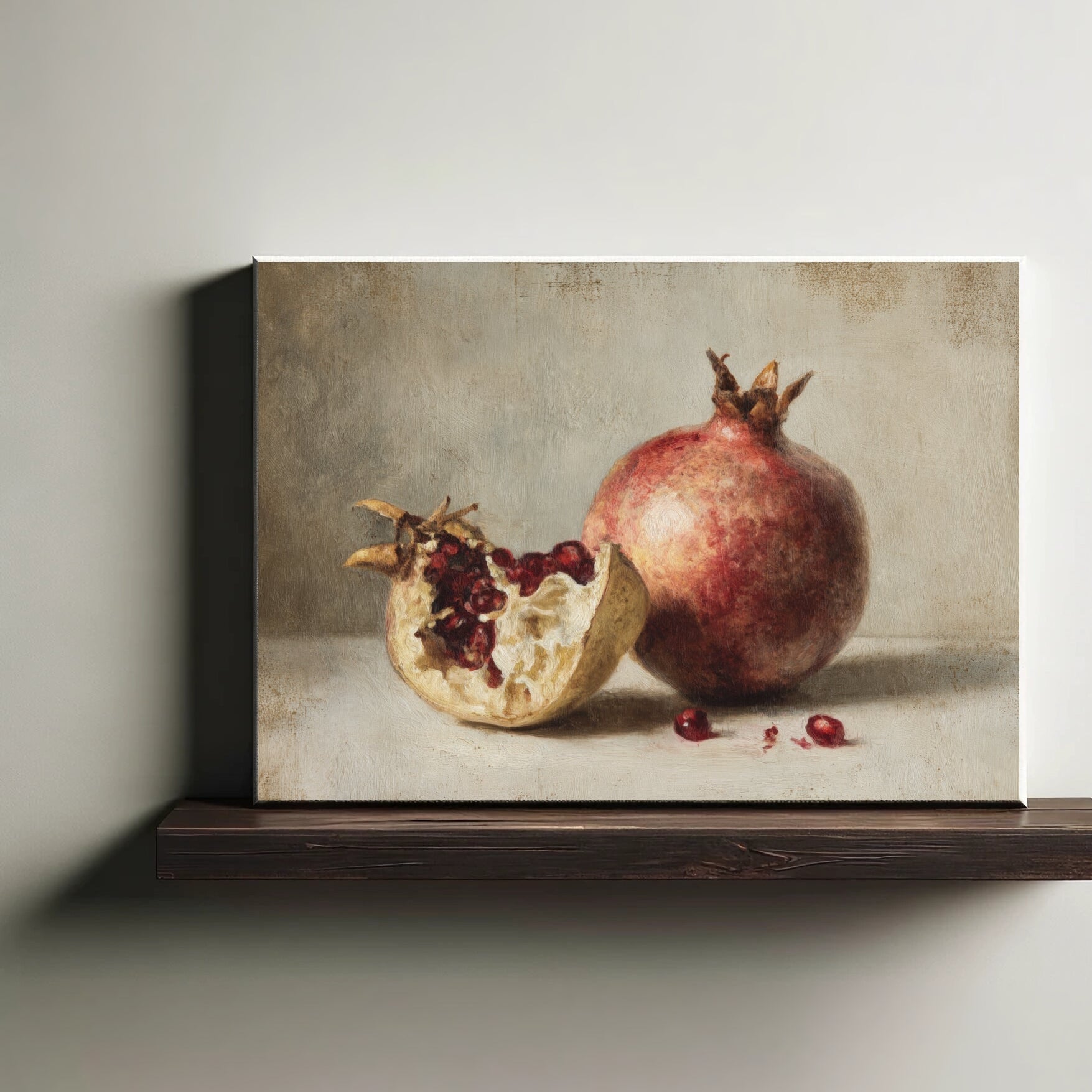 Framed artwork of a pomegranate on a wooden shelf against a neutral wall.